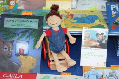 DAK SCHF Rollipuppe Anna mit Büchern.JPG